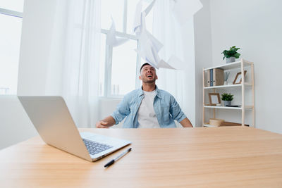 Portrait of woman using laptop at desk in office