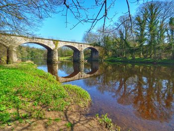 Arch bridge over river against sky