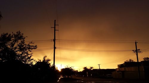 Silhouette of electricity pylon against sky