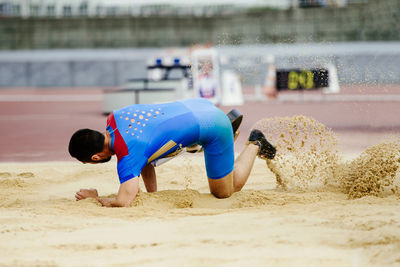 Portrait of boy playing with sand at beach