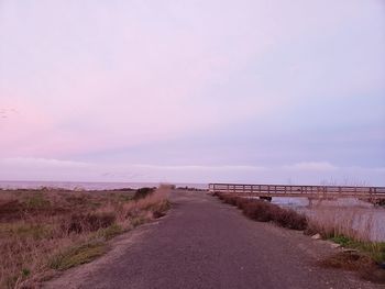 Road by land against sky during sunset