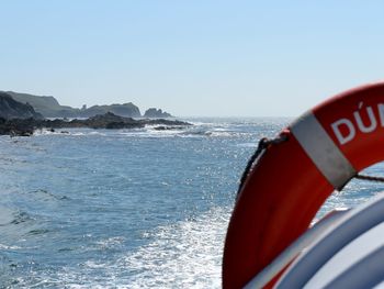 Close-up of red boat in sea against clear sky