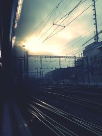 Railroad tracks against cloudy sky