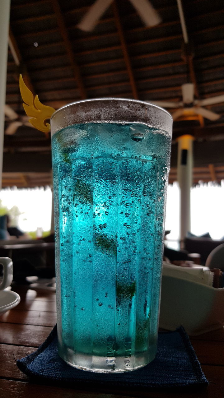 CLOSE-UP OF GLASS OF DRINK ON TABLE