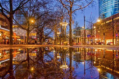 Large puddle after abundant rainfall reflecting the city lights on central coolsingel boulevard
