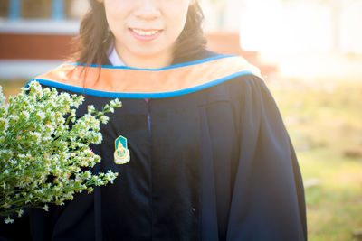 Woman standing by white flowering plants