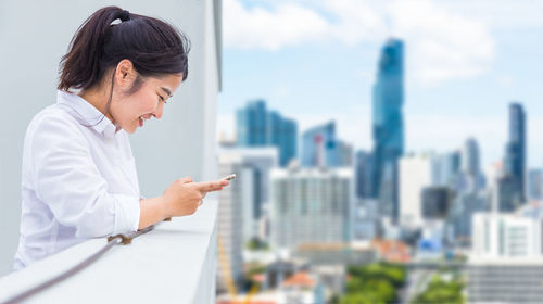 Side view of woman looking at city buildings