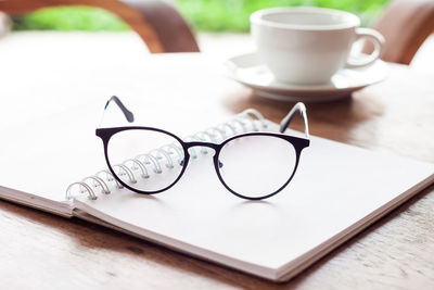 Close-up of glasses and book on table