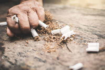 Cropped image of hand crushing cigarettes