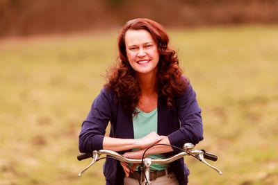 Portrait of smiling young woman riding bicycle