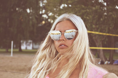 Portrait of young woman wearing sunglasses in park