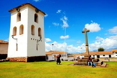 People in front of building against blue sky