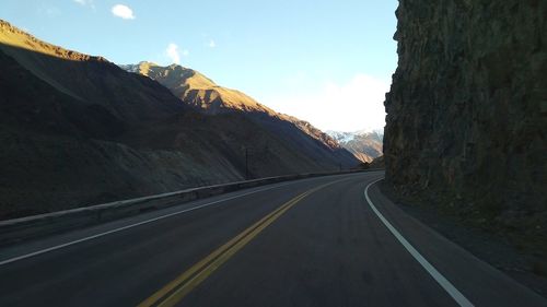 Empty road by mountain against sky