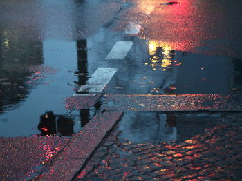High angle view of raindrops on puddle at street