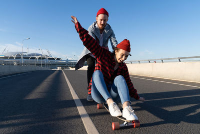 Stylish man and woman skating on longboard enjoy time together. urban fashion and trendy activity