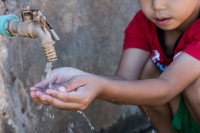 Midsection of boy drinking water