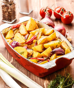 Roast potatoes with fresh vegetables on the rustic
