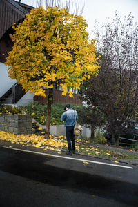 Man walking on road in autumn
