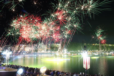 Firework display over river at night