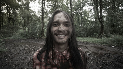 Portrait of smiling young woman in forest