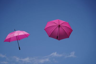 Low angle view of umbrella against clear blue sky