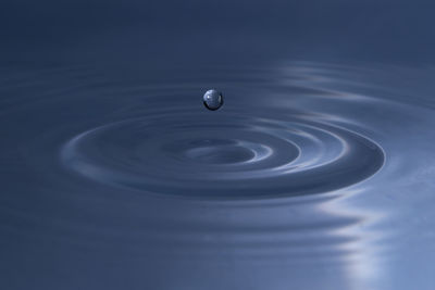 Close-up of water drop above wavy surface