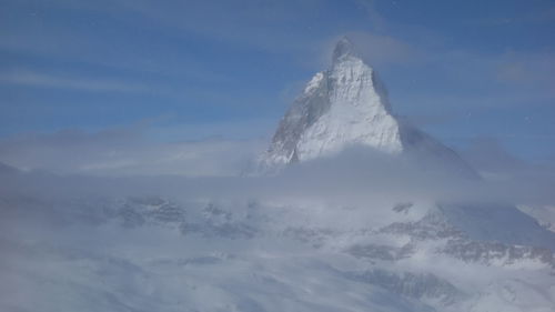 Snow covered landscape against sky