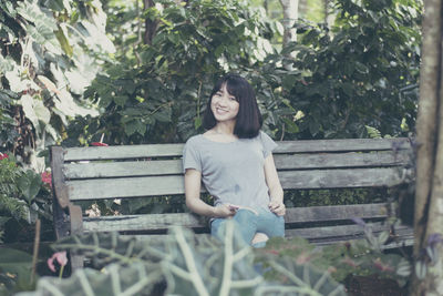 Woman sitting on bench in park