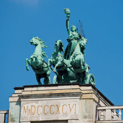 Low angle view of statue against blue sky