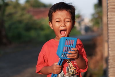 Happy child grasping, expressing joy with open mouth, radiating individuality and happiness