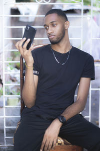 Young man using mobile phone. close-up portrait of young man. portrait of a handsome man in black .