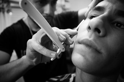 Barber shaving mans beard in the barber shop