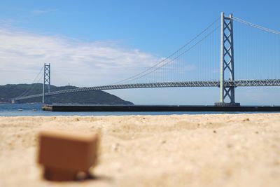 Suspension bridge over sea against sky