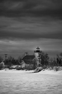 Lighthouse by sea against sky