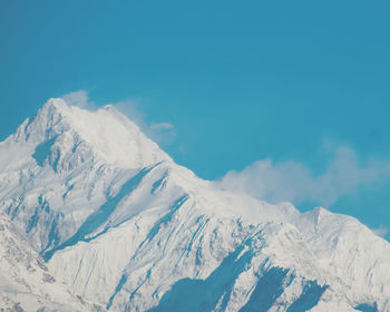 Low angle view of snowcapped mountains against sky