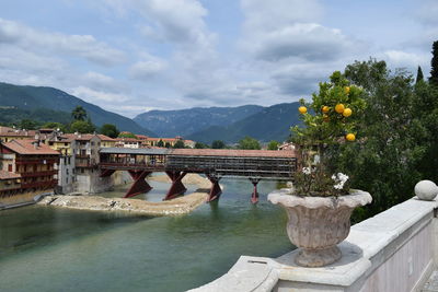 Arch bridge over river against cloudy sky