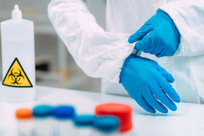 Woman putting protective splash face shield on. laboratory safety equipment.