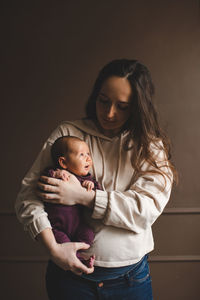 Mother with daughter against wall