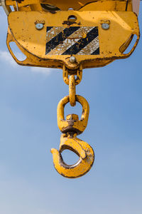 Low angle view of metal against blue sky