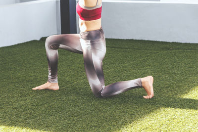 Low section of woman exercising on grass