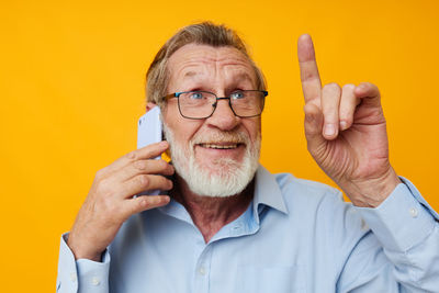 Smiling senior man gesturing while talking on phone