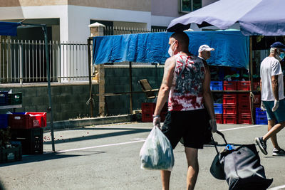 Rear view of people walking on street in city