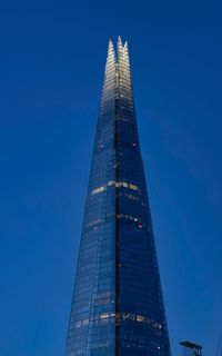 Low angle view of modern building against blue sky