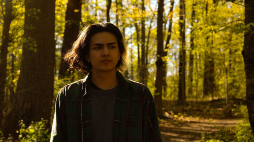 Portrait of beautiful young woman standing in forest