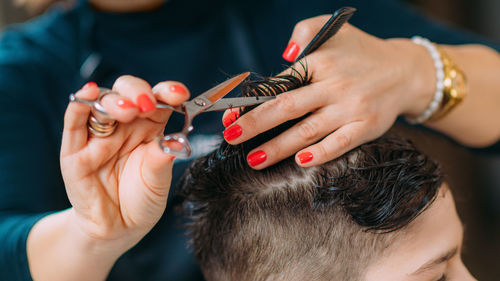 Boy having his hair cut in hairdresser's salon