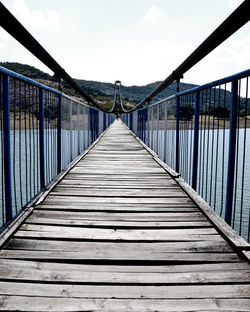 Empty footbridge against sky