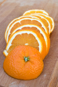 Close-up of orange slice on wooden cutting board