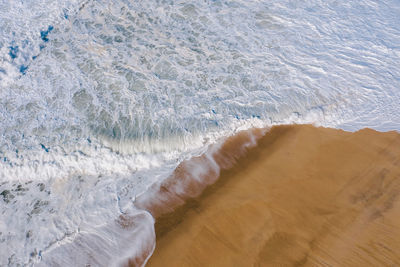 High angle view of waves rushing towards shore