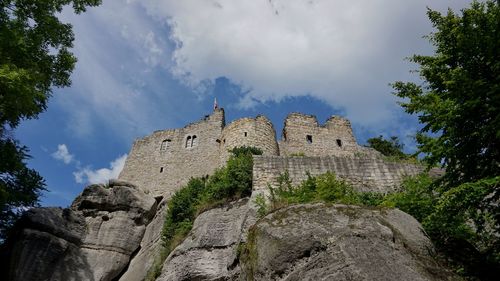 Low angle view of old building against cloudy sky