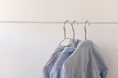 Clothes on hangers, blue shirts on a white background, shopping, clothes wardrobe